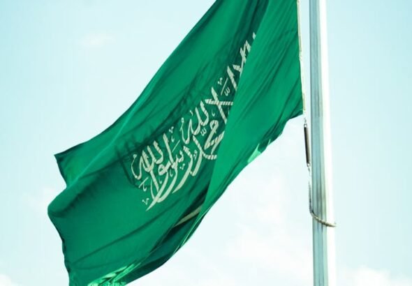 saudi arabian flag waving against blue sky